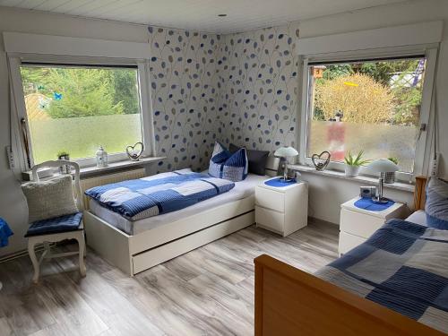 een slaapkamer met 2 bedden en 2 ramen bij Ferienwohnung Gartenblick in Nordenham