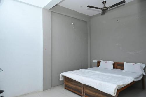 a bedroom with a bed with a ceiling fan at Hotel Swastik Palace in Maheshwar
