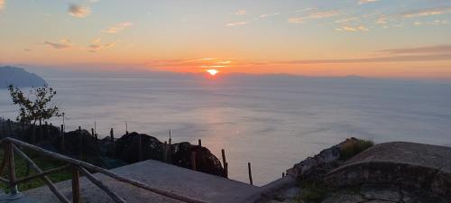 una vista del sole che sorge sull'oceano di Le Finestre di Amalfi ad Amalfi