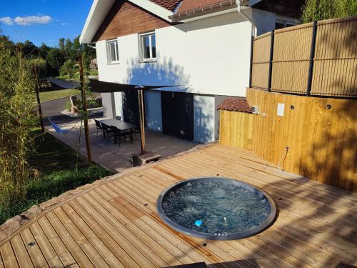 a deck with a hot tub on top of it at Gîte la p'tite rivière in Saint-Nabord