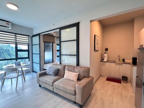 a living room with a couch and a table at JQ1 SEA & POOL or CITY View WIFI I WASHING MACHINE for Some Units I CUCKOO WATER Jesselton Quay by R2 in Kota Kinabalu