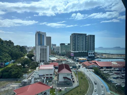 a city with tall buildings and a street with cars at JQ1 SEA & POOL or CITY View WIFI I WASHING MACHINE for Some Units I CUCKOO WATER Jesselton Quay by R2 in Kota Kinabalu