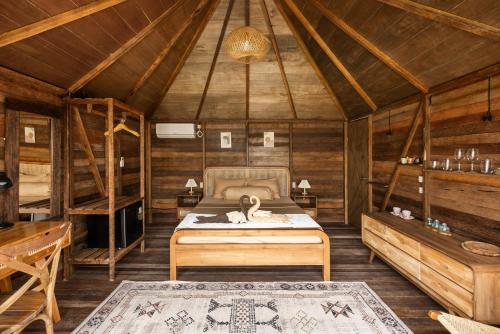 a bedroom with a bed in a wooden cabin at Bali Cozy Bungalows, Nusa Dua Benoa in Nusa Dua