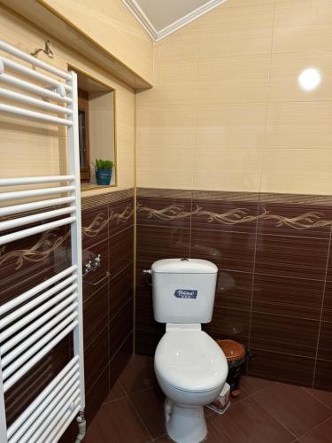 a bathroom with a white toilet in a room at Къща за гости Арнаудови in Kostandovo