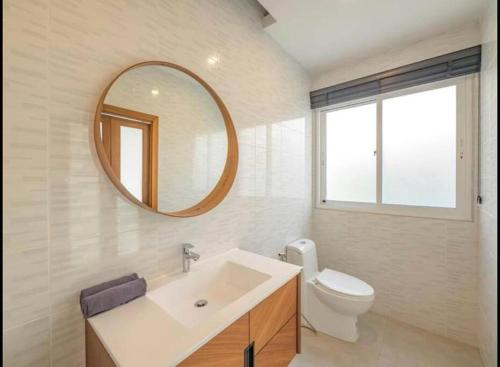 a bathroom with a sink and a toilet and a mirror at Villa Mikalamai in Ban Thung