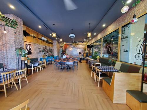 a restaurant with tables and chairs in a room at Khách Sạn The One Hotel 1 in Cà Mau