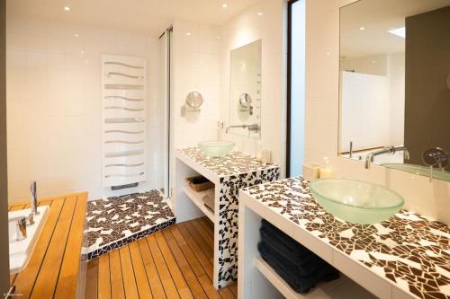 y baño con 2 lavabos y bañera. en Superbe maison d'architecte entièrement climatisée avec piscine et spa professionnel, en Talence