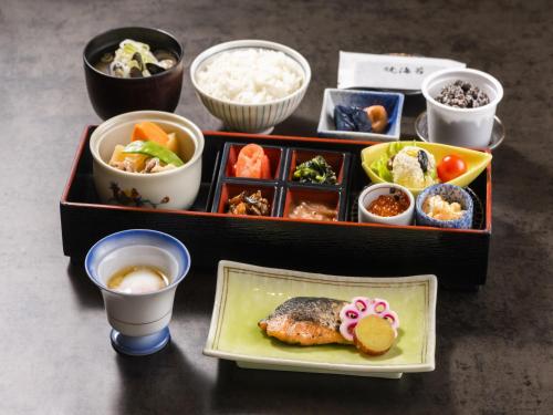 a table with two trays of food and bowls of rice at HOTEL MYSTAYS PREMIER Sapporo Park in Sapporo
