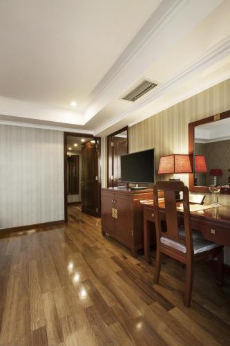a hotel room with a desk and a mirror at Rex Hotel in Ho Chi Minh City