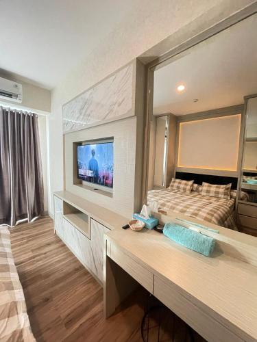 - une chambre avec un lit et une télévision dans l'établissement Grand Kamala Lagoon By Beatrix Property, à Pekayon Satu