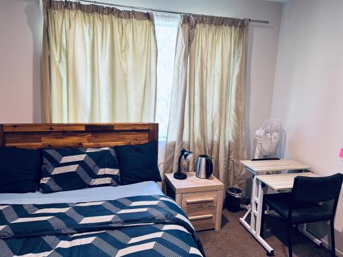 a bedroom with a bed and a desk and a window at Comfy Stay in Room with Security & Privacy - Room 102 in Auckland