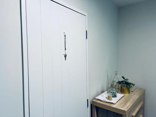 a white door in a room with a wooden table at Comfy Stay in Room with Security & Privacy - Room 102 in Auckland