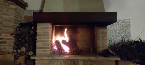 a brick fireplace with a fire in it at La dimora dei Sanniti in Busso