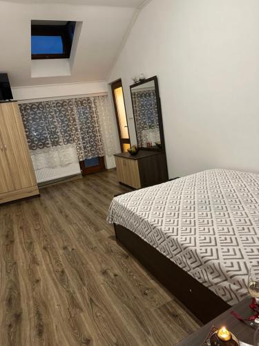 a bedroom with a bed and a wooden floor at Къща за гости Арнаудови in Kostandovo