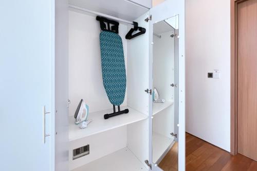 a bathroom with white shelves and a mirror at Soho Suites KLCC by Leala in Kuala Lumpur