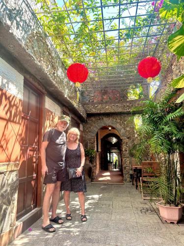 a man and woman standing in a building with red lanterns at Sầm Sơn Boutique Hotel Phan Thiết in Phan Thiet