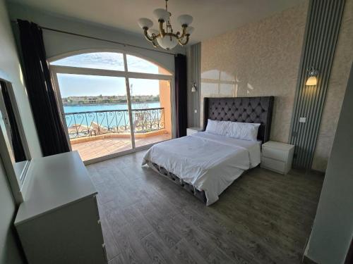 1 dormitorio con cama y ventana grande en فيلا على البحر بمسبح خاص وشاطى رملي en Durat  Alarous