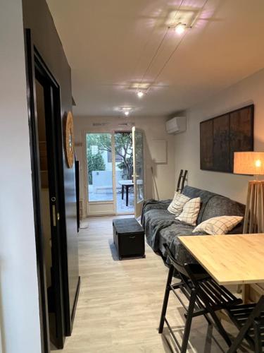un salon avec un canapé et une table dans l'établissement Maison avec jardin, au Grau-du-Roi