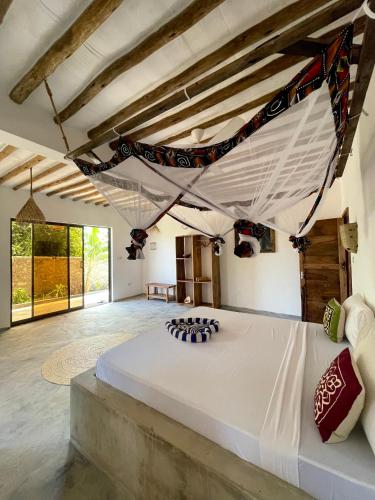 a bedroom with a large white bed in a room at Chunga Changa in Matemwe