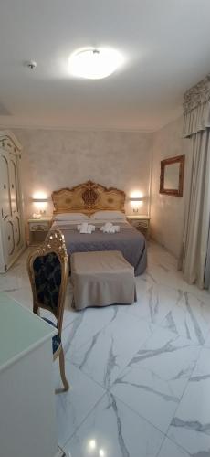 a bedroom with a king sized bed and a marble floor at HOTEL PARADISE in Porto Cesareo