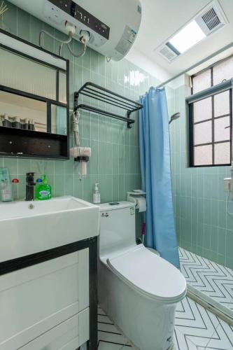 Un baño con inodoro, lavabo y espejo. en Shanghai Century Old House Downtown B&B, en Shanghái