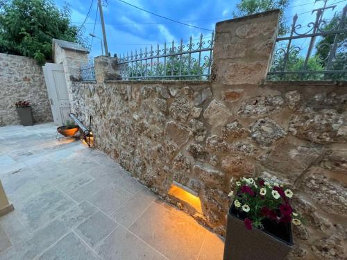 een stenen muur met bloemen op een binnenplaats bij Vivi's Apartments Loft in Spetses