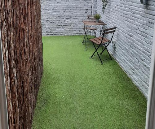 a patio with green grass and two chairs and a table at Bonito Alojamiento F in Valencia