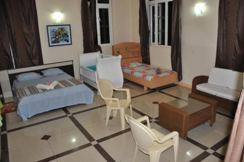 a living room with two beds and a crib at Le Refuge in Rodrigues Island