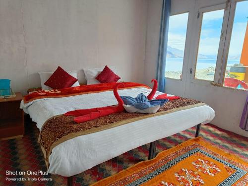 a bedroom with a bed with a view of the ocean at Blue Chill Cottage Pangong in Lukung