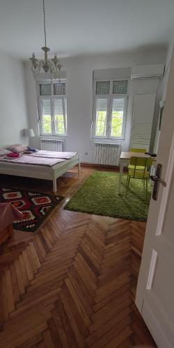 a room with a bed and a table and chairs at Cricket 2 Hostel in Belgrade