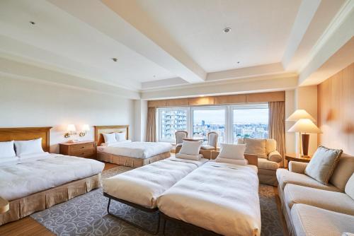 a hotel room with two beds and a couch at HOTEL MYSTAYS PREMIER Sapporo Park in Sapporo