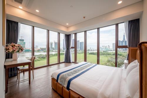 1 dormitorio con 1 cama, escritorio y ventanas en The Metropoles - Sy's Home, en Ho Chi Minh