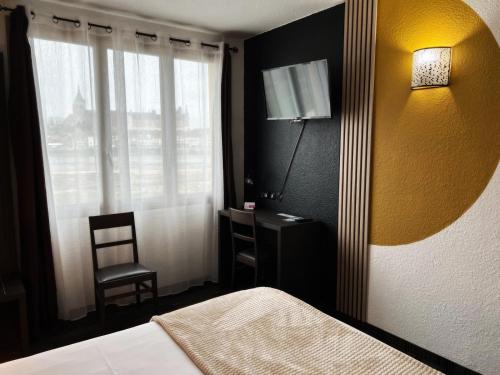 ジアンにあるBrit Hotel Confort Gienのベッドルーム(ベッド1台、ランプ、椅子付)
