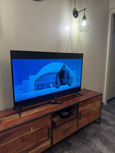 a flat screen tv sitting on top of a wooden entertainment center at Logement de Ville 4 chambres proche de Lille in Tourcoing