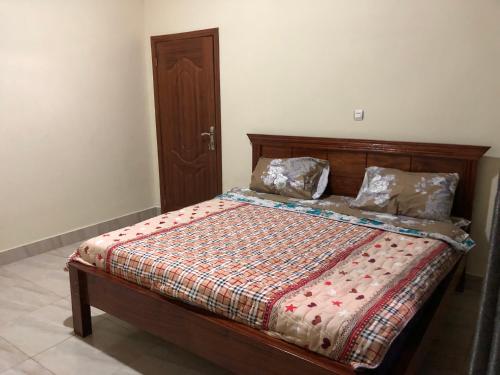 ein Schlafzimmer mit einem Bett mit einer Bettdecke und Kissen in der Unterkunft Luxury Furnished and Serviced Home in Kigali