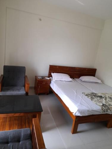 1 dormitorio con 1 cama y 1 silla en Apple, en Kāladi