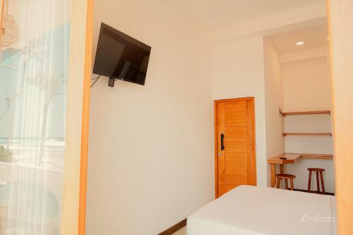 um quarto com uma cama e uma televisão na parede em HotelNuvin AHANGAMA em Ahangama