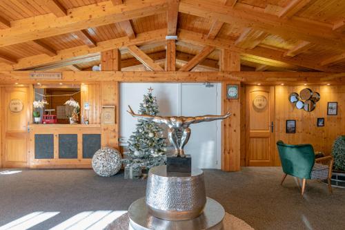 a living room with a christmas tree and a statue at Le Chalet d'Antoine - Centre de Megève in Megève