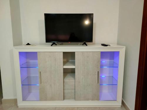 a flat screen tv on top of a white entertainment center at Policarpo-centro in Torrevieja