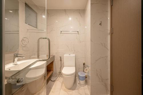 Baño blanco con lavabo y aseo en D1 Mension Luxury Apartment- Chloe Dang, en Ho Chi Minh