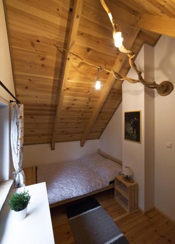 a bedroom with a bed in a room with wooden ceilings at Leśny Kącik Zelwa in Zelwa