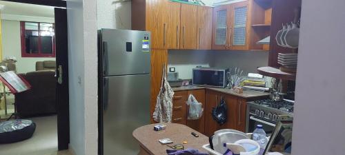 a kitchen with a stainless steel refrigerator and wooden cabinets at شقة بمطار القاهرة in Cairo