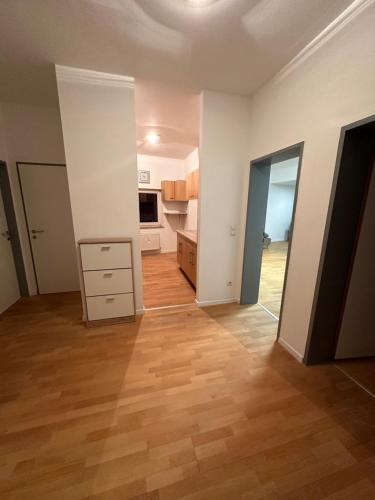 an empty room with a wooden floor and a kitchen at Geräumiges sonniges Apartment mit Bergblick in Imst