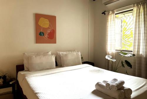 Tien B&B & Bistro في فاغاتور: غرفة نوم بسرير ابيض عليها مناشف