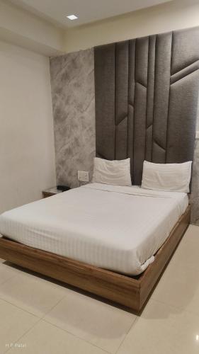 a bedroom with a large bed with white sheets at hotelbhavya in Ahmedabad