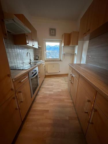 a kitchen with wooden cabinets and a window at Geräumiges sonniges Apartment mit Bergblick in Imst