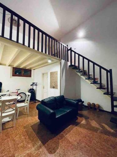 sala de estar con sofá y escalera de caracol en San felice studio en Bolonia