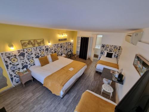 Habitación de hotel con 2 camas y TV de pantalla plana. en Cit'Hotel Les Atlantes, en Médis