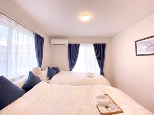 a bedroom with two beds and a window at 海まで3分！アメリカンビレッジまで5分 最大8名 Moana in Chatan
