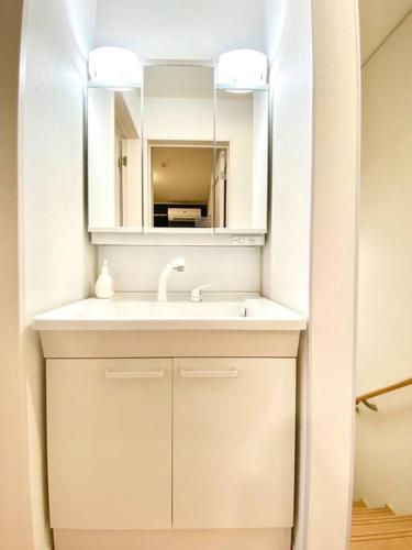 a white bathroom with a sink and a mirror at 海まで3分！アメリカンビレッジまで5分 最大8名 Moana in Chatan